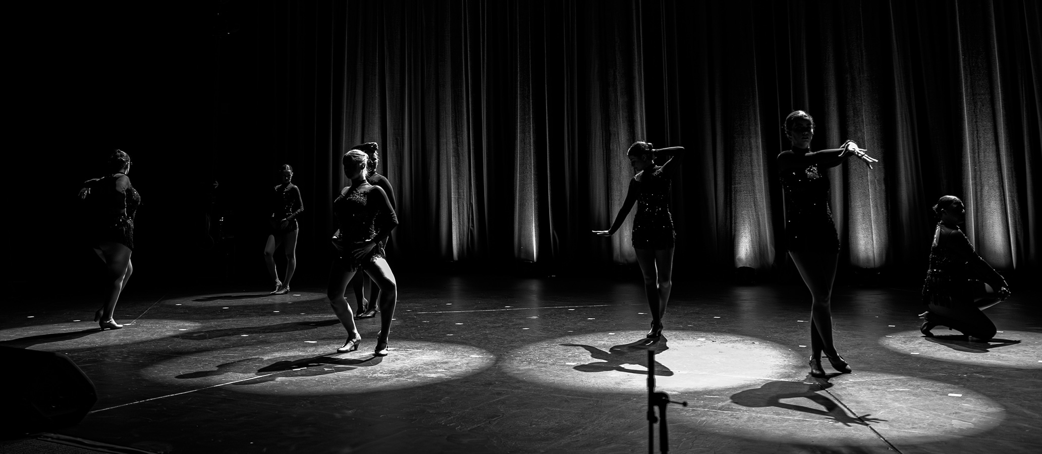 Black and white image of Superstars senior class dancers posed on stage ready to start their performance